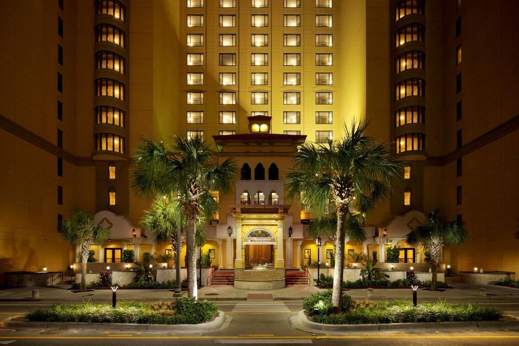 默特尔比奇Hilton Grand Vacations Club Anderson Ocean Myrtle Beach的一座棕榈树环绕的建筑,位于高楼前