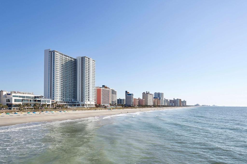 默特尔比奇Hilton Grand Vacations Club Ocean Enclave Myrtle Beach的享有海滩和大海的美景,拥有高大的建筑