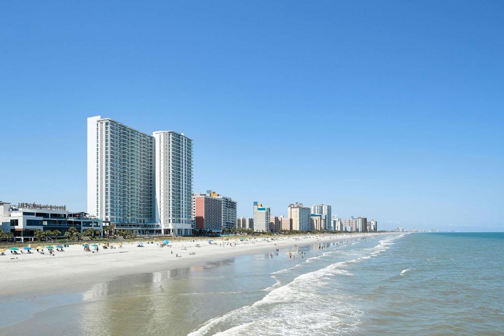 默特尔比奇Hilton Grand Vacations Club Ocean Enclave Myrtle Beach的一片拥有众多人和建筑的海滩
