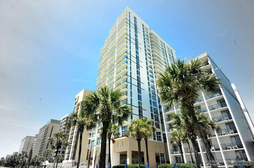 默特尔比奇Hilton Grand Vacations Club Ocean 22 Myrtle Beach的一座高大的建筑,前面有棕榈树
