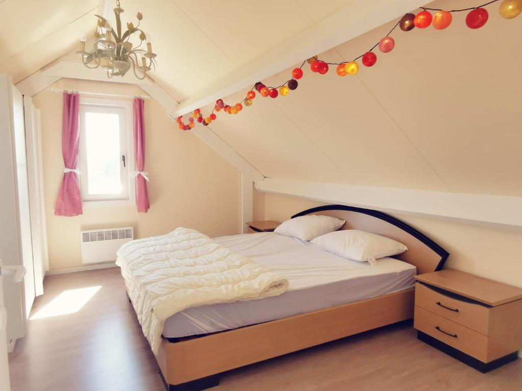 德哈恩Izzy's Rainbow House的一间卧室设有一张天花板上带圣诞装饰的床。