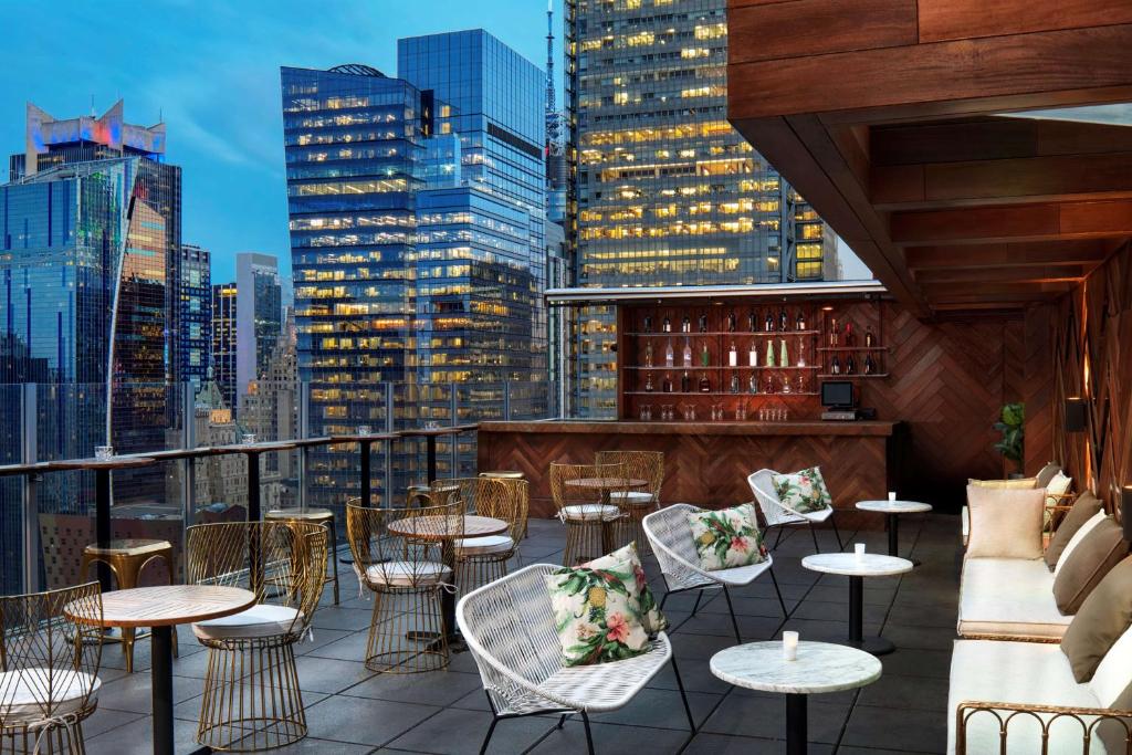 纽约纽约时代广场西希尔顿逸林酒店的享有带桌椅的屋顶酒吧的景致。