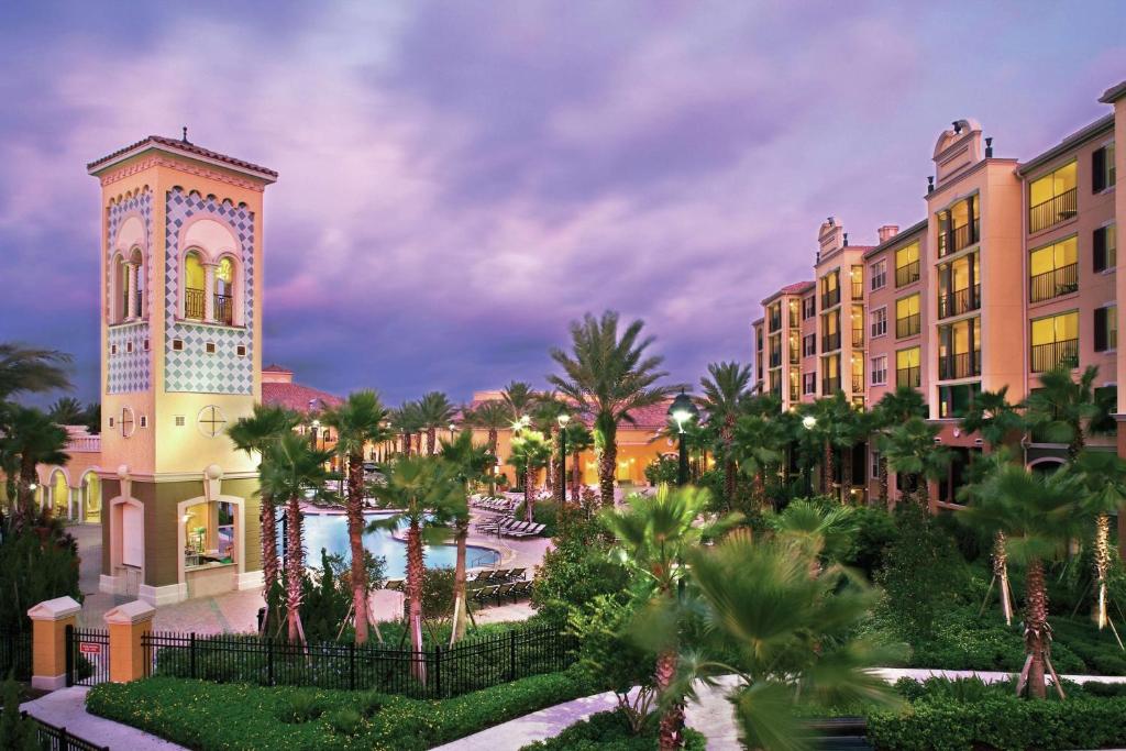 奥兰多Hilton Grand Vacations Club Tuscany Village Orlando的一个带钟楼和游泳池的度假胜地