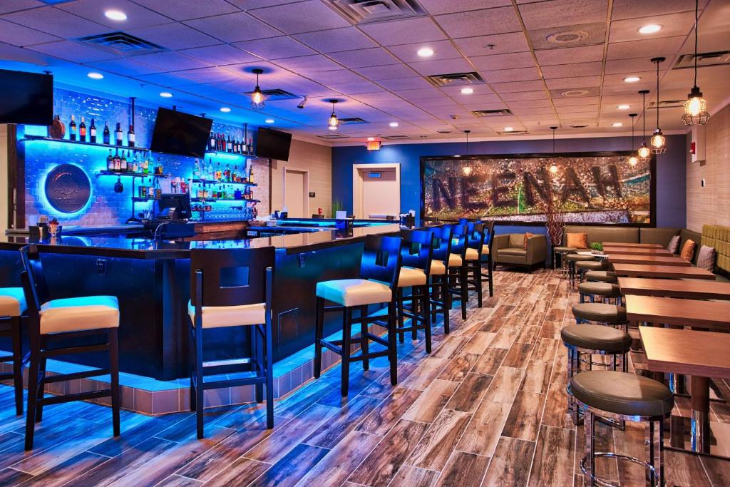 尼纳尼纳希尔顿逸林酒店 的餐厅里设有蓝色墙壁和凳子的酒吧