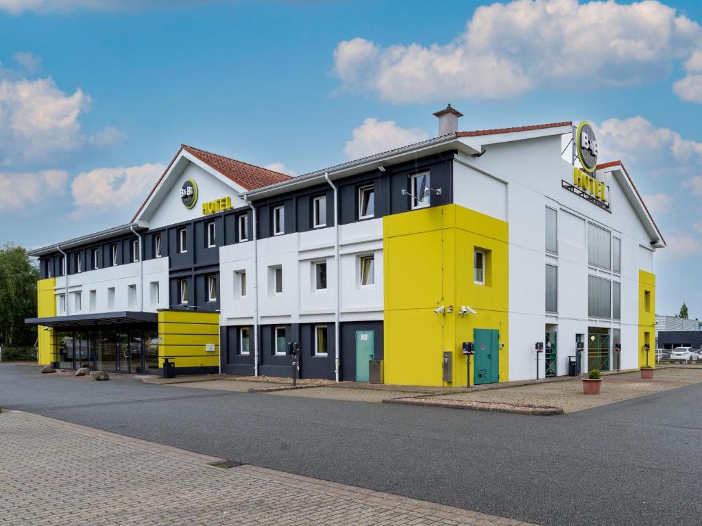 汉诺威B&B Hotel Hannover-Nord的街道边的黄色和白色建筑