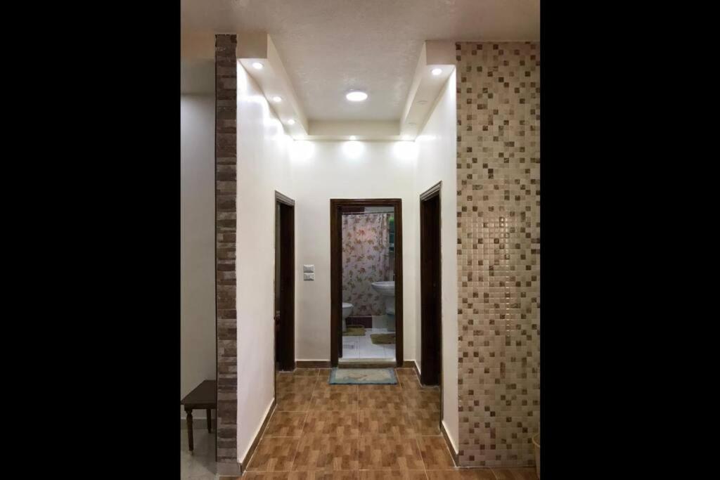 卡拉克Your cozy apartment in Al-Karak的走廊设有瓷砖墙,走廊设有镜子