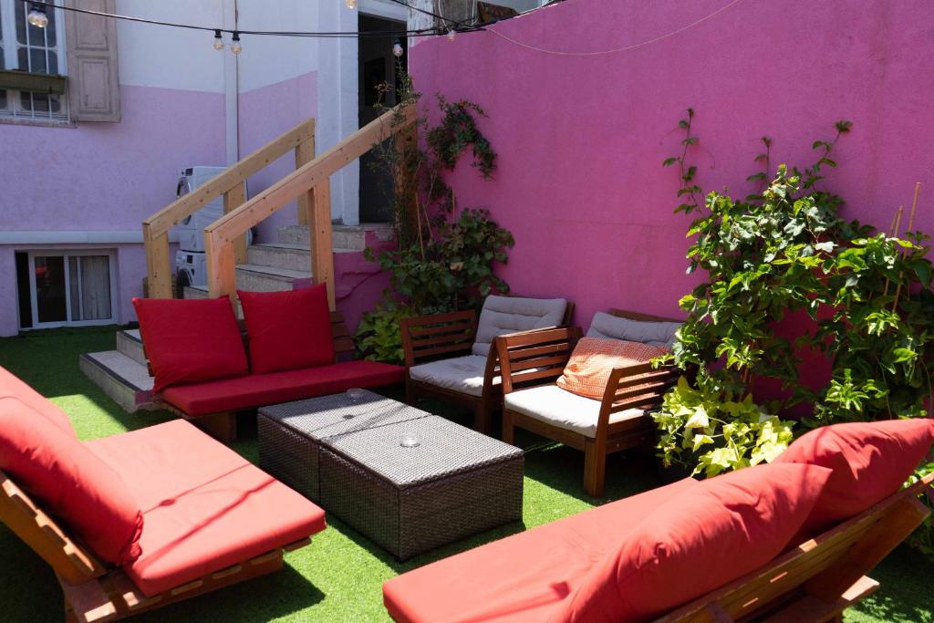 特拉维夫Ajami Guest House的一个带红色家具和紫色墙壁的庭院