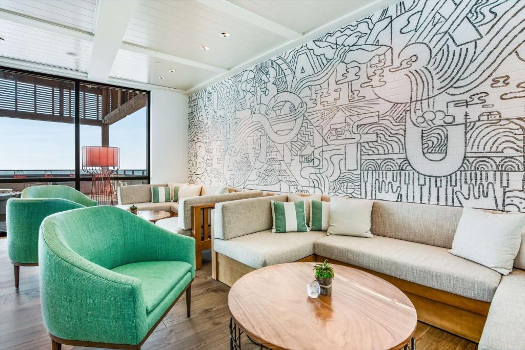 格尔夫海岸The Lodge at Gulf State Park, A Hilton Hotel的墙上有一幅大型壁画的客厅