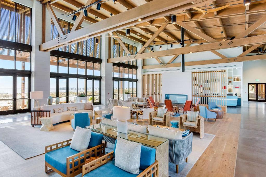 格尔夫海岸The Lodge at Gulf State Park, A Hilton Hotel的客厅配有许多家具和窗户。