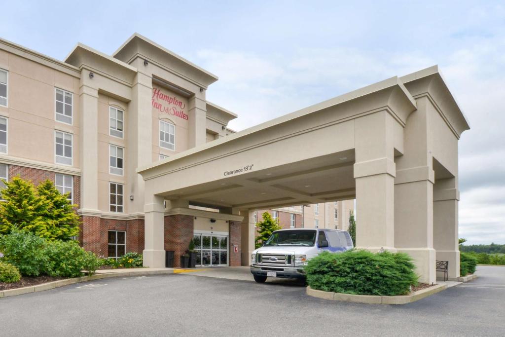 普里茅斯Hampton Inn & Suites by Hilton Plymouth的停在酒店前停车场的汽车