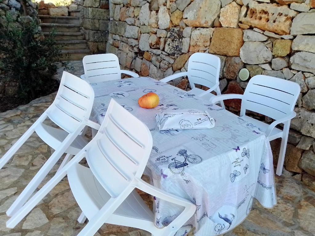 莫尔恰诺迪莱乌卡Domus Veretum的一张桌子,上面有白色的椅子和橙子
