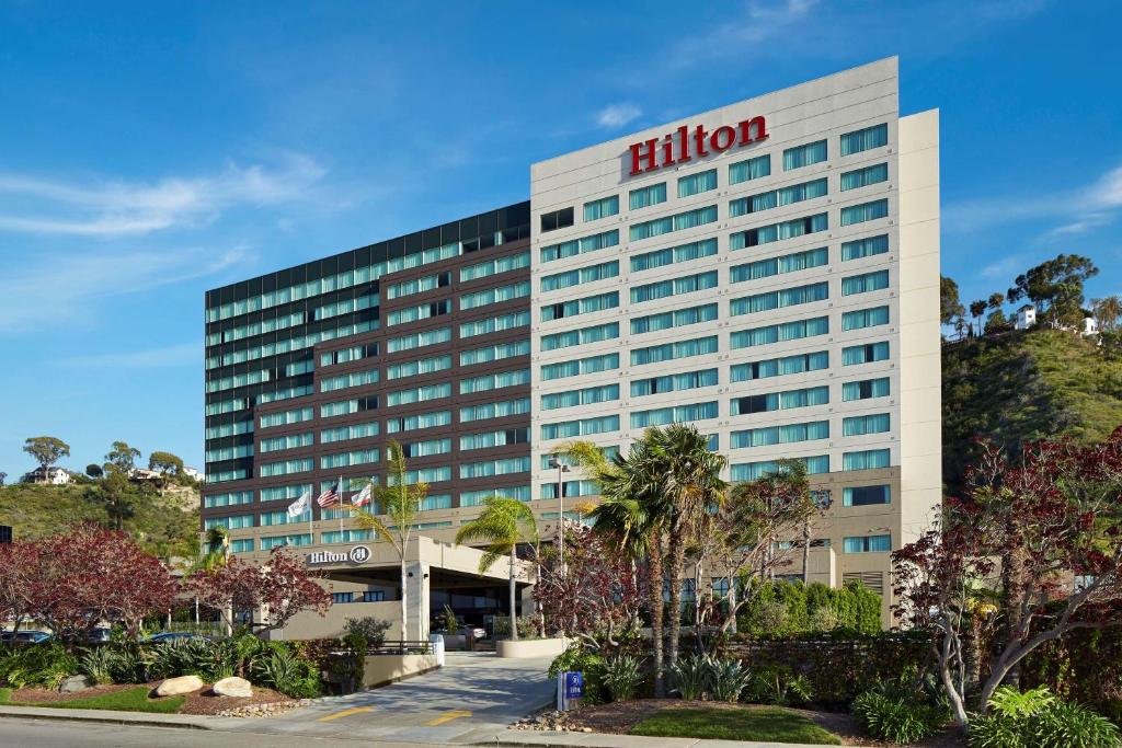 圣地亚哥圣地亚哥米申山谷希尔顿酒店的一座酒店大楼,上面有希尔顿标志