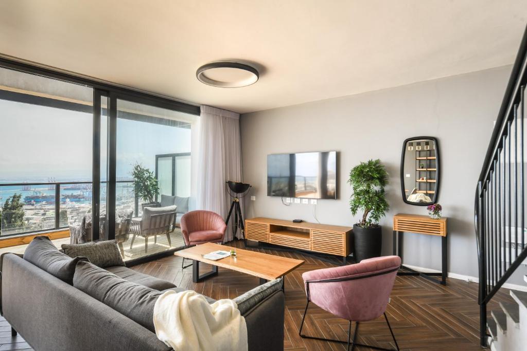 海法Stunning 2BR Apartment with Balcony and Ocean View in the Heart of Haifa by Sea N' Rent的客厅配有沙发和桌子