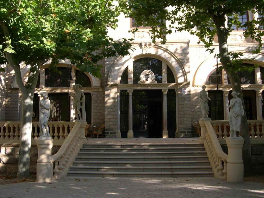 阿拉贡省阿拉马芭雅瑞斯温泉康体公园酒店的前面有楼梯和雕像的建筑