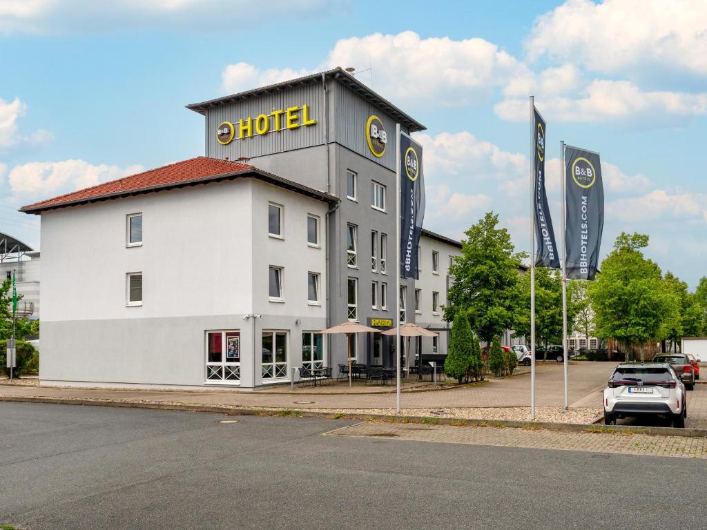 汉诺威B&B Hotel Hannover-Lahe的一座白色的大建筑,上面有酒店标志