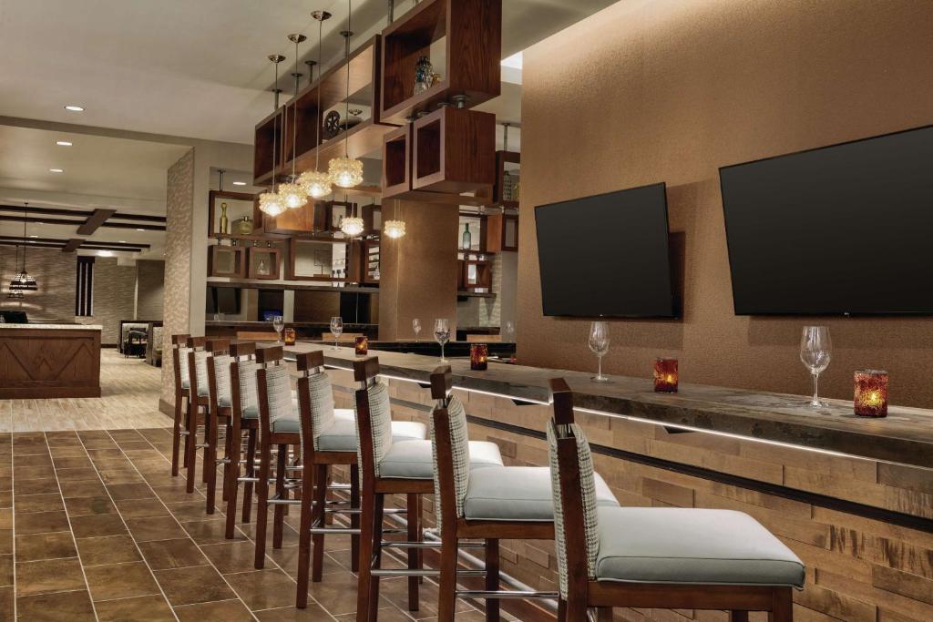 南乔丹南约旦盐湖城希尔顿大使馆套房酒店 的一间酒吧,房间里摆放着一排椅子