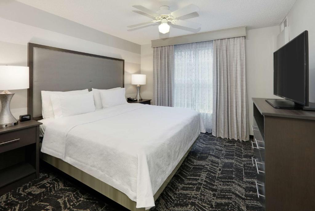 切斯特菲尔德圣路易斯切斯特菲尔德希尔顿霍姆伍德套房酒店的酒店客房设有一张大床和一台电视。