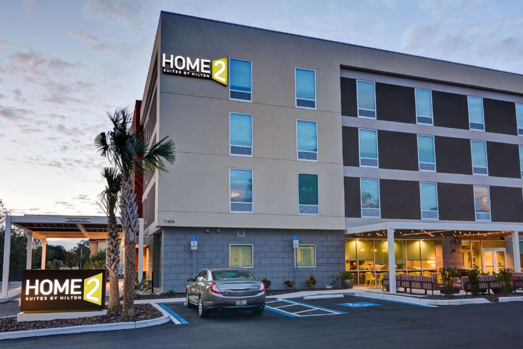 坦帕Home2 Suites By Hilton Tampa USF Near Busch Gardens的停车场内有停车位的酒店