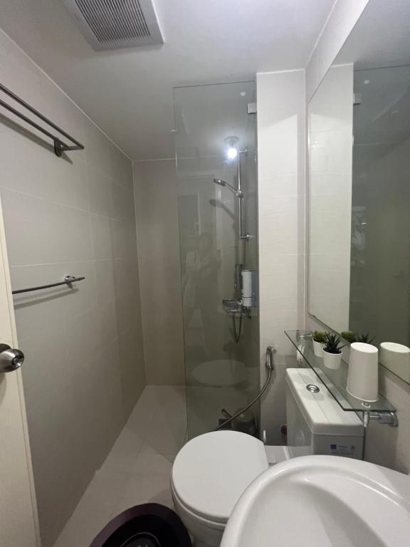 马尼拉The Bahamas and Maldives Suites at Azure Residences near Manila Airport的一间带卫生间和玻璃淋浴间的浴室