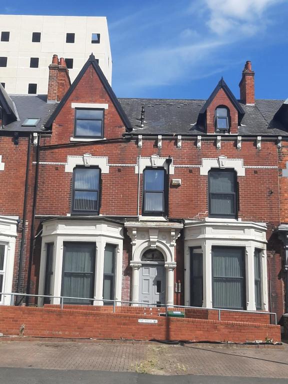 米德尔斯伯勒Exclusive Self-contained flat in Middlesbrough的红砖房子,有白色门