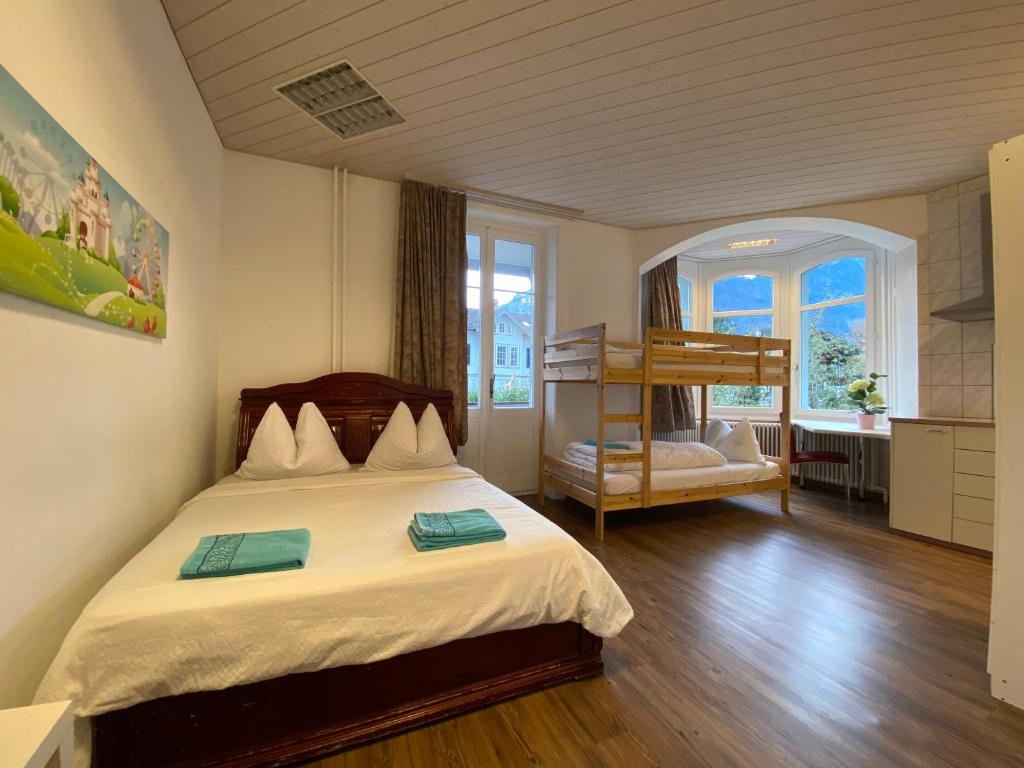 因特拉肯因特拉肯马可宾馆的一间卧室配有一张床和一张双层床。