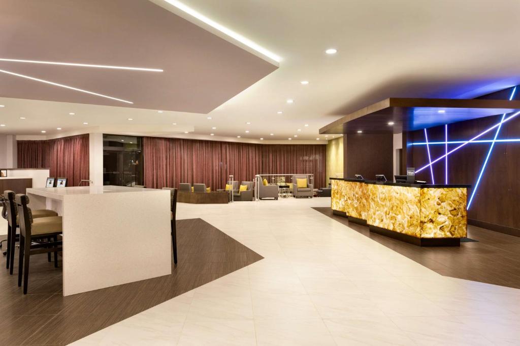 米西索加希尔顿逸林酒店多伦多机场西店的大堂,设有酒吧和椅子