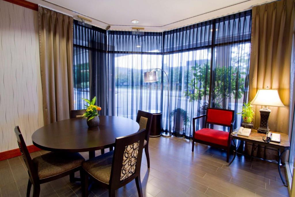 里士满温哥华机场/里奇蒙汉普顿酒店的客厅配有桌椅和大窗户