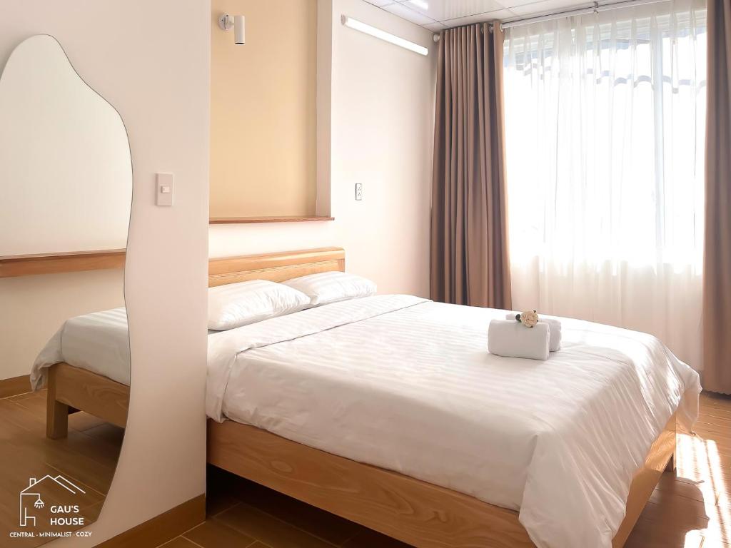 岘港Central, Minimalist and Cozy - Gau's House的卧室配有白色的床,上面有白色的手提箱
