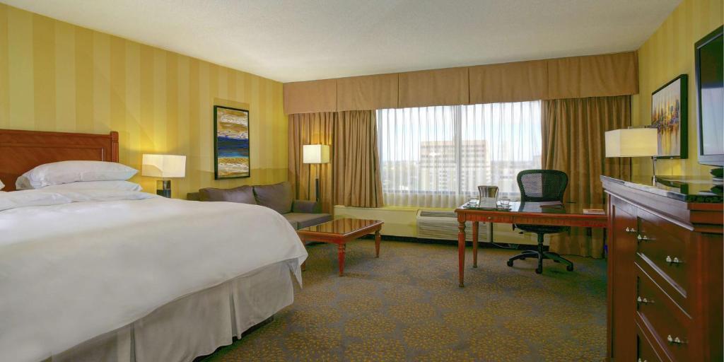 伦敦伦敦希尔顿逸林酒店的酒店客房设有一张大床和一张书桌。