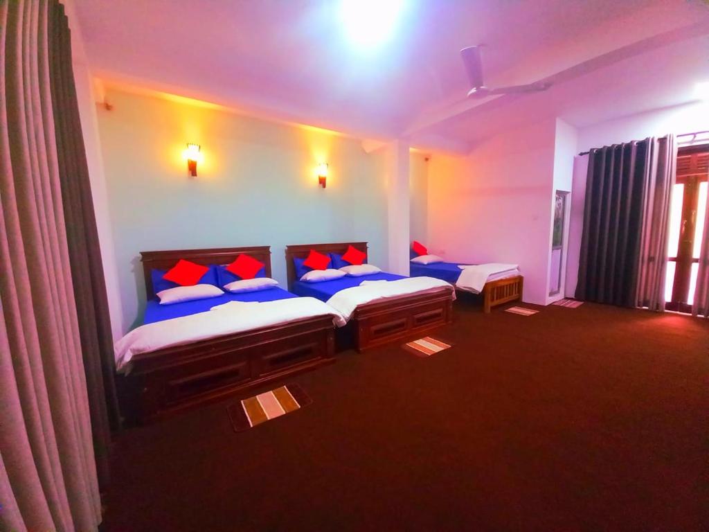 埃拉Kithaya Ella的一间卧室配有两张带蓝色和红色枕头的床