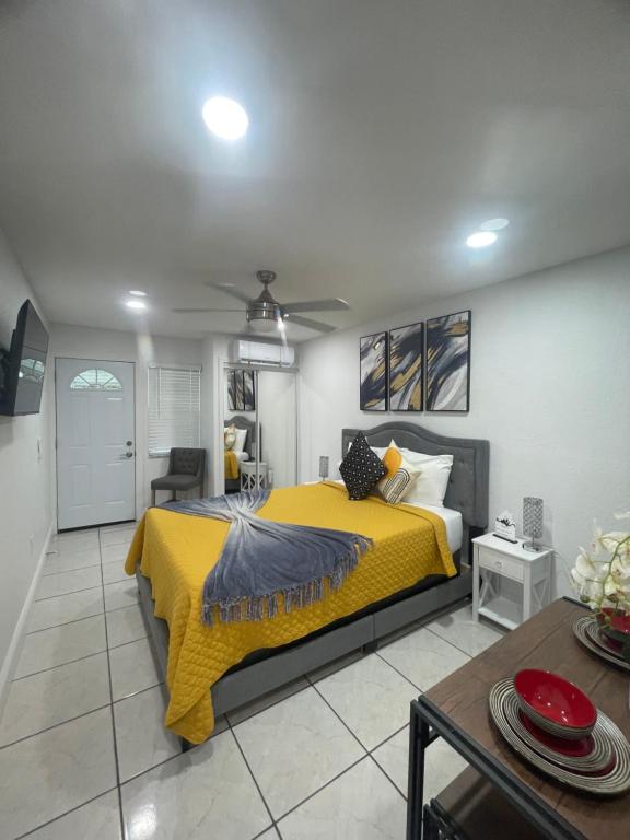 坦帕tranquilo y fantastico apartamento cerca de playas y areopuerto的一间卧室配有一张黄色的床和一张桌子