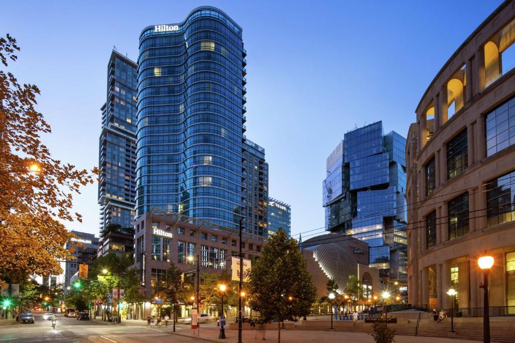 温哥华Hilton Vancouver Downtown, BC, Canada的一条城市街道,晚上有高大的建筑
