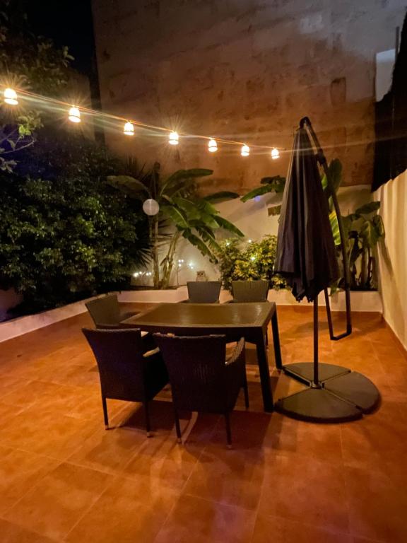 马略卡岛帕尔马Casa de Limon的庭院配有桌椅和遮阳伞。