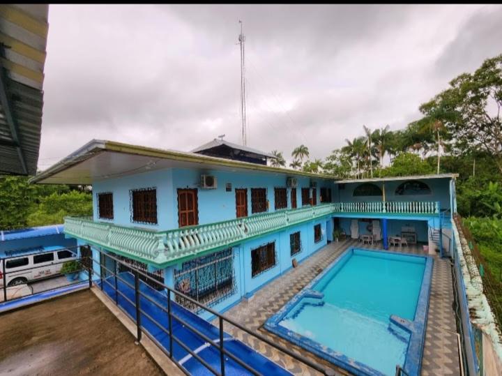 莱蒂西亚Hotel Alto Amazonas的一座带游泳池的大型蓝色房屋