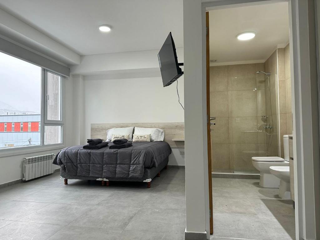 乌斯怀亚Jainen Apartamentos的一间卧室配有一张床,浴室设有淋浴。