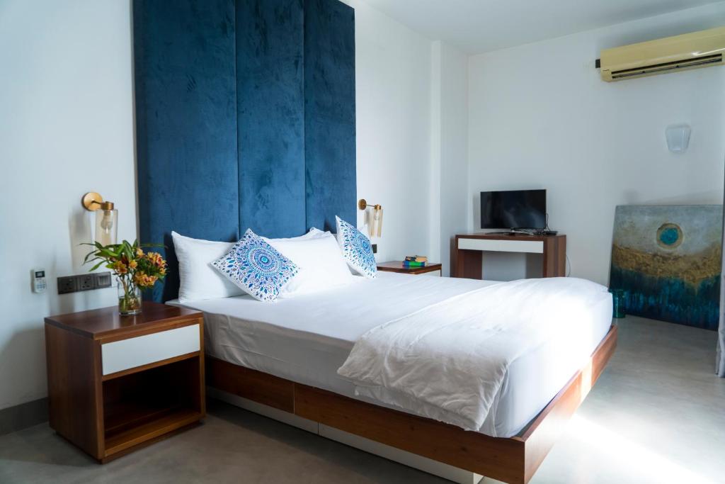 科伦坡Four Petals Inn的一间卧室配有一张蓝色墙床