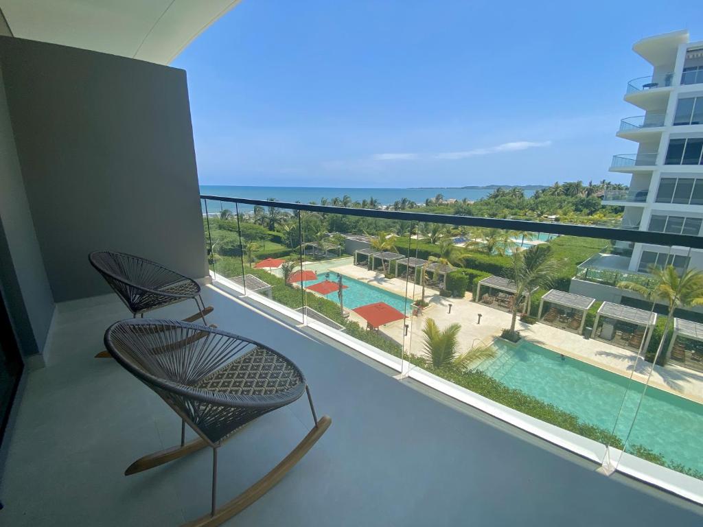 卡塔赫纳Apartamento de Lujo Morros Zóe - Manzanillo - Cartagena的阳台配有椅子,享有游泳池的景色