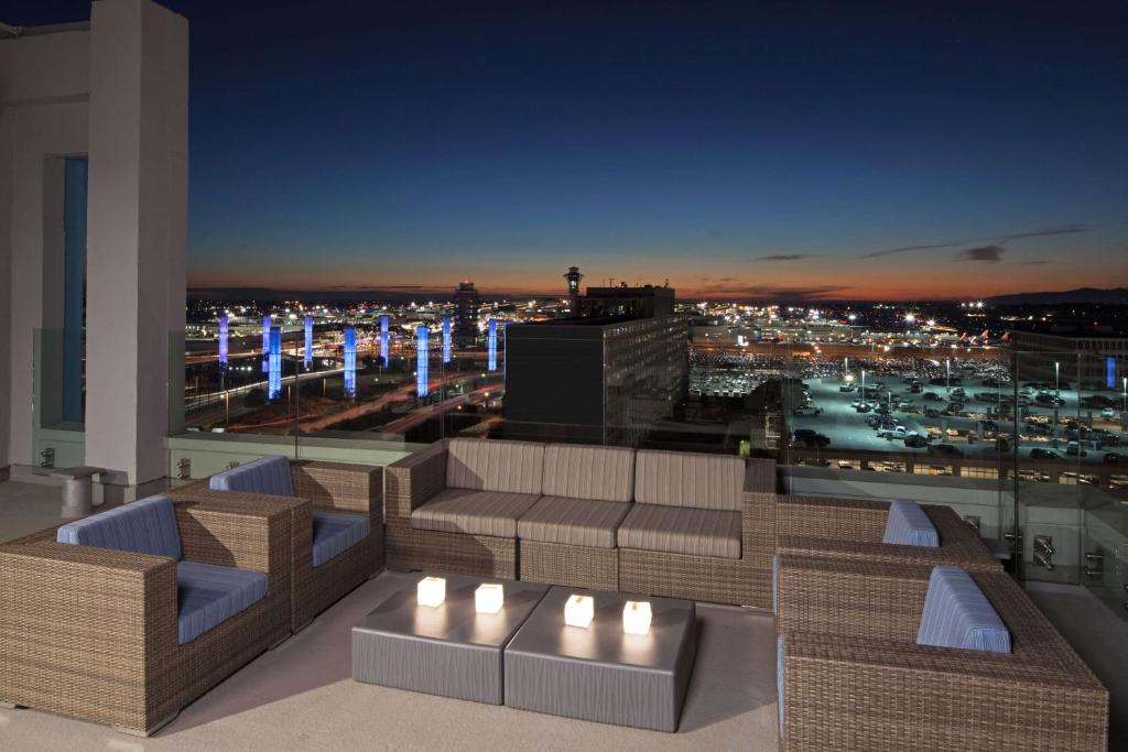 洛杉矶洛杉矶H酒店，希尔顿格芮精选酒店的屋顶庭院,晚上可欣赏到城市美景
