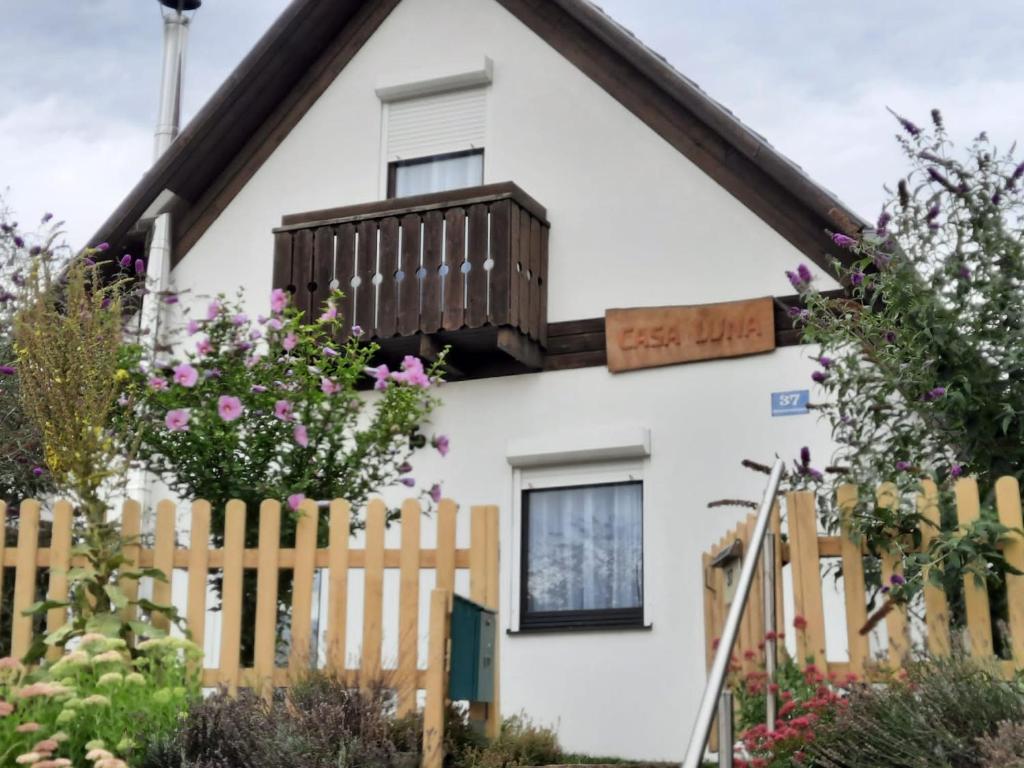 多内斯科尔岑Casa Luna的白色的房子,带有木栅栏和鲜花