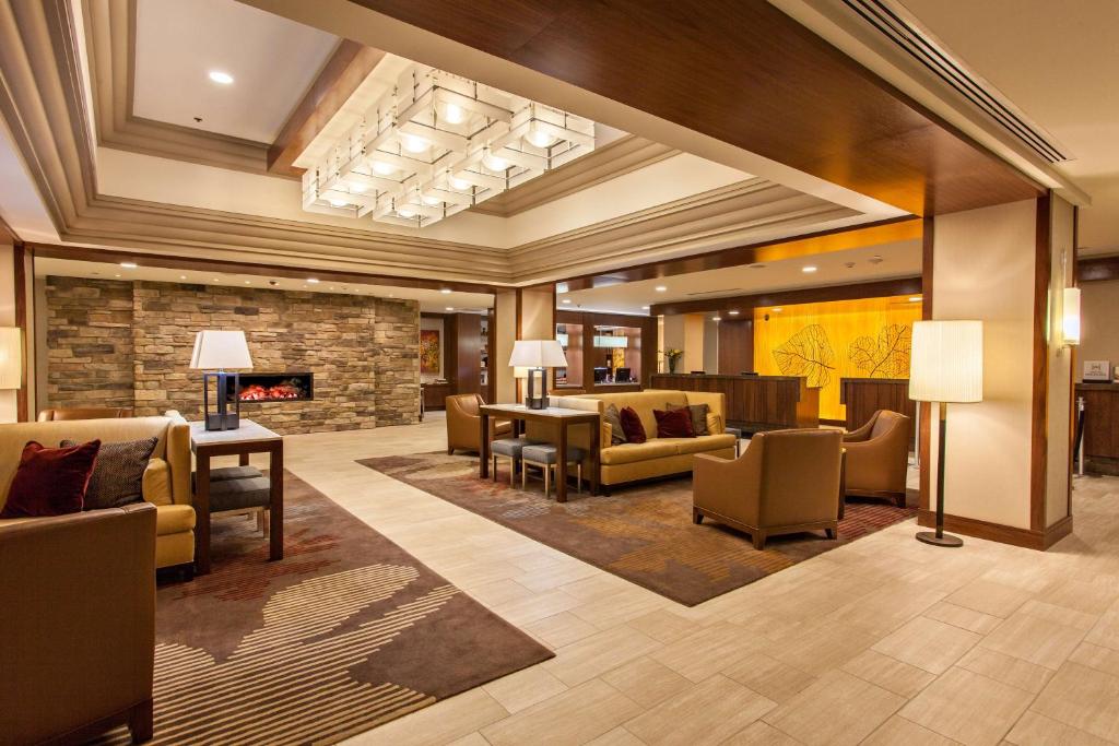 匹兹堡格林豪泰希尔顿逸林酒店绿树店的大堂配有沙发、椅子和壁炉