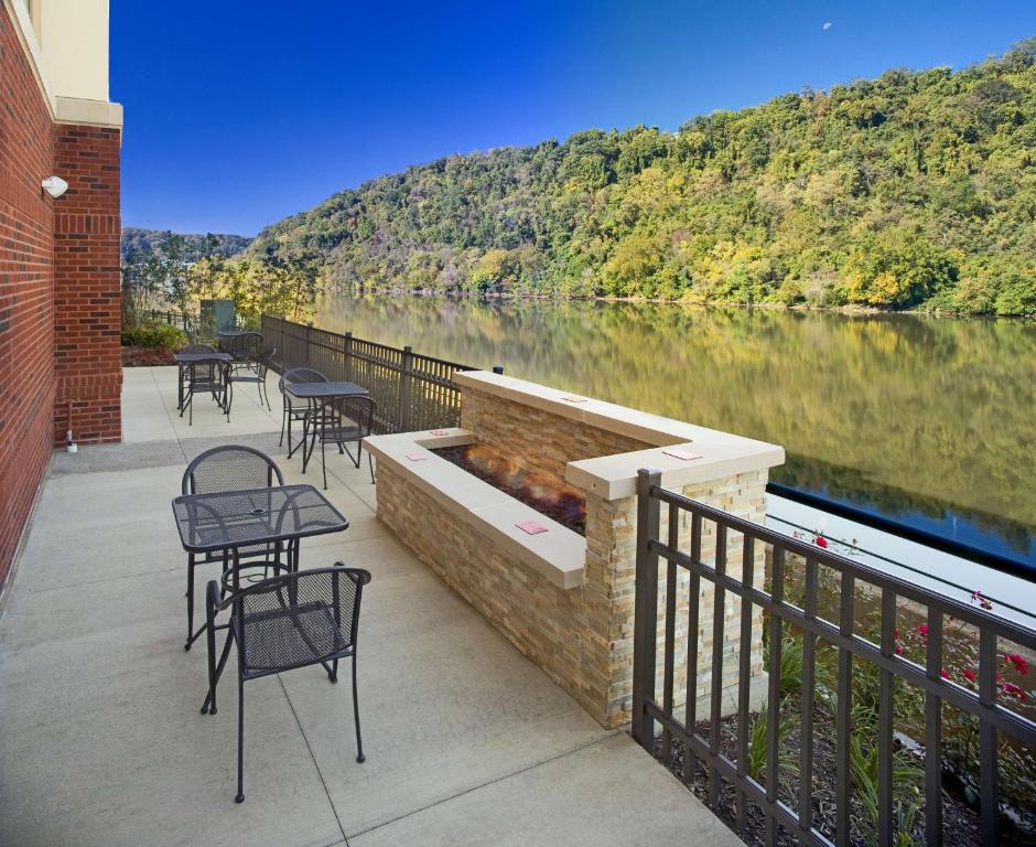 West HomesteadHampton Inn & Suites Pittsburgh Waterfront West Homestead的河畔带桌椅的天井