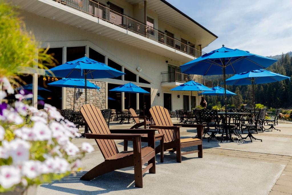 Orofino贝斯特韦斯特河滨酒店的一组配有蓝色遮阳伞的桌椅
