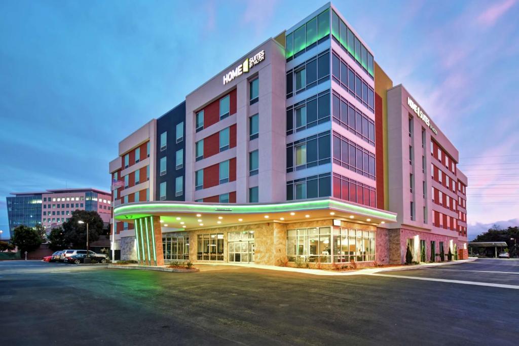 南旧金山Home2 Suites By Hilton San Francisco Airport North的停车场内有灯的建筑的酒店