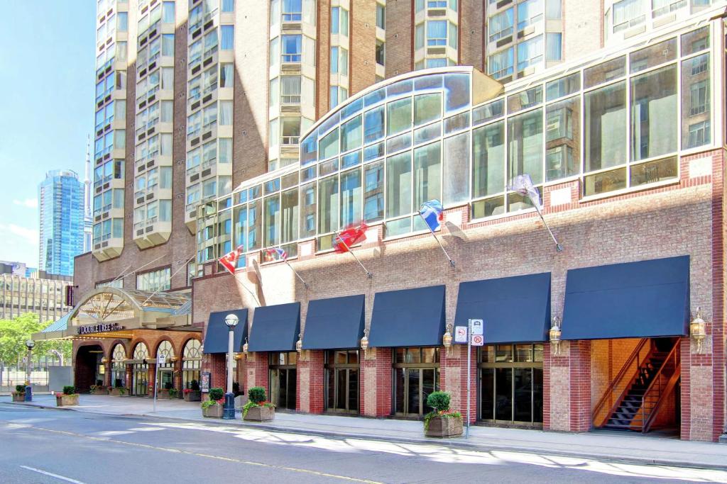 多伦多多伦多市中心希尔顿逸林酒店的街道边有蓝色遮阳篷的建筑