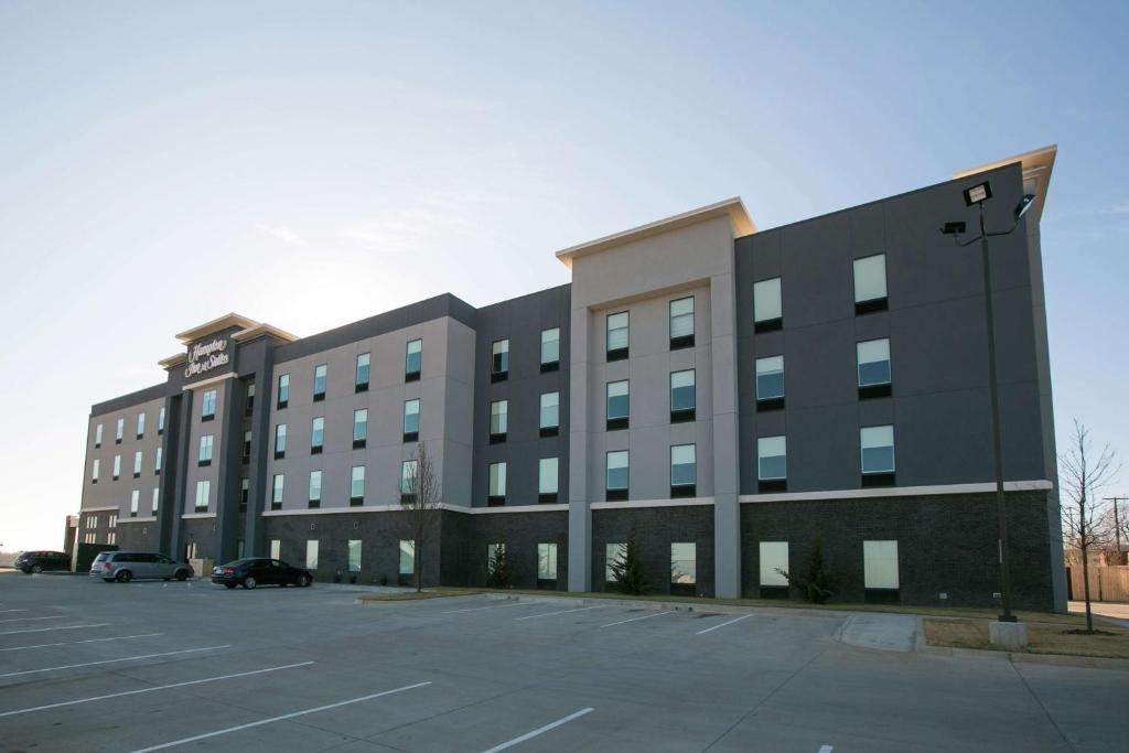 StroudHampton Inn & Suites Stroud的一座大型建筑,前面设有停车场