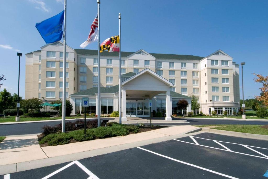 奥因斯米尔斯希尔顿奥因斯米尔斯花园酒店（Hilton Garden Inn Owings Mills）的停车场前有旗帜的酒店