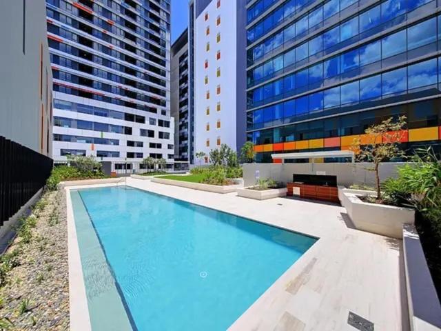 布里斯班Bedroom & Private Bathroom in Modern Inner Brisbane Apartment的大楼前的大型游泳池