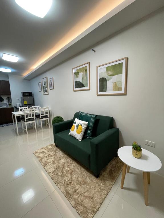 Lapu Lapu CityFLY & REST GUESTHOUSE - Mactan-Cebu International Airport的客厅配有绿色沙发和桌子