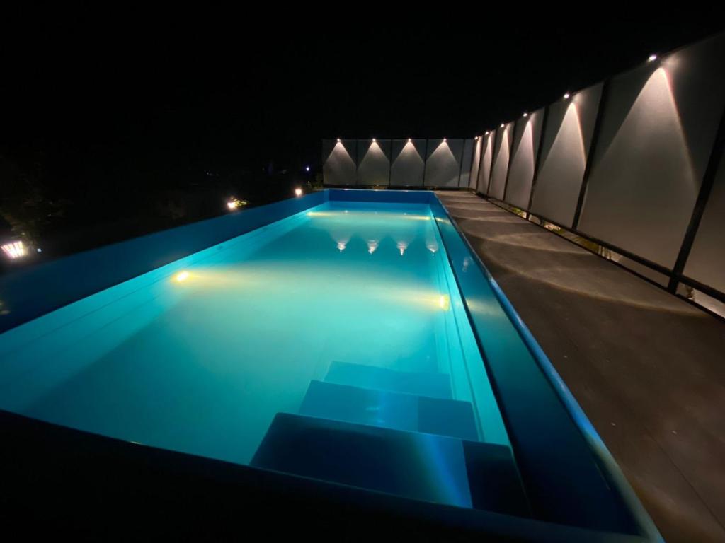 蓬蒂切里Le Poshe Beachview的夜间游泳池,灯光蓝色