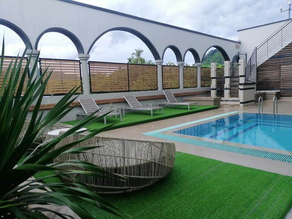 瓜埠兰卡威海景酒店的庭院设有游泳池和绿草